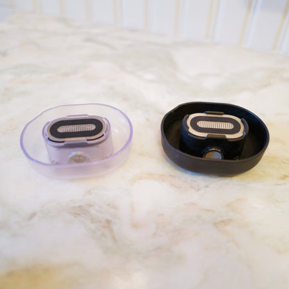 A pair of Razor Rinsers, in clear and black - made to effortlessly clean your razor, save water, and keep your sink clean while you shave.